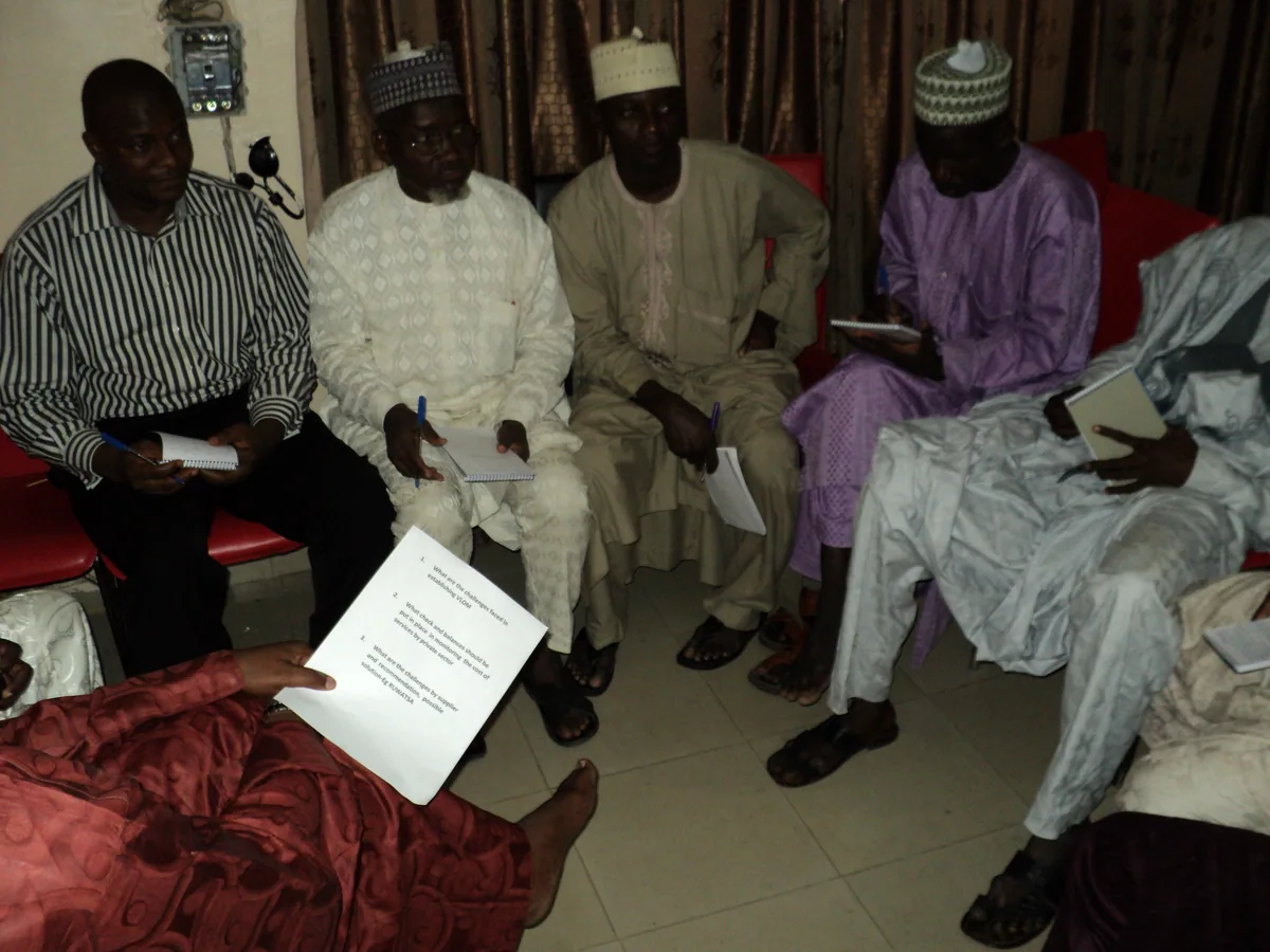 Participants seated together with notebooks during a community discussion